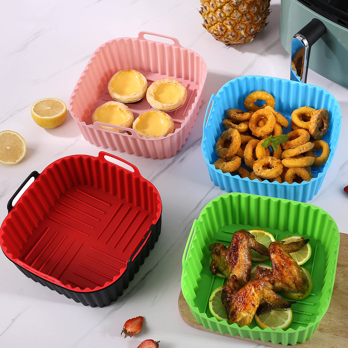 Air fryer trays in different colors with food inside.