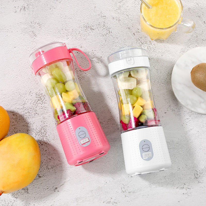 Two white and pink portable blenders with fruits inside.